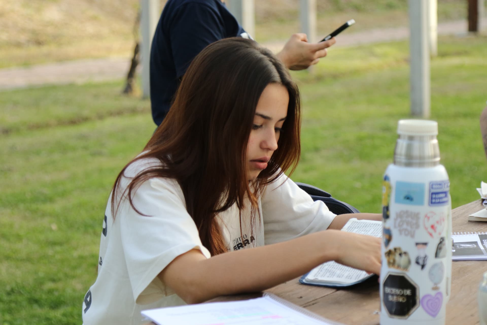 Estudiante leyendo la Biblia y tomando notas al aire libre
